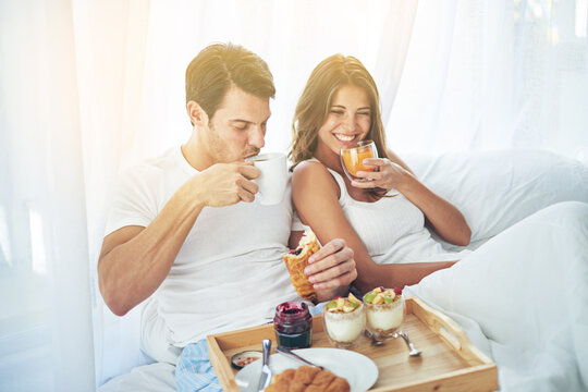 Breakfast is better when you share it in bed. Shot of a loving young couple enjoying breakfast in bed.