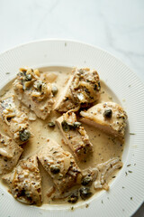 Chicken breasts in mustard sauce on white plate