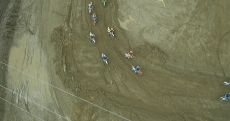 Aerial above amateur dirt bike riders on Motocross track during race in California desert