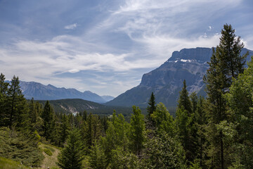 Natural landscape - Bow River Valley, Rocky Mountains, coniferous forest and beautiful sky with clouds. Summer tourism in the mountains
