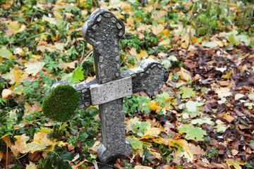 Abandoned concrete cross with moss