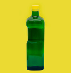Green glass bottle on yellow background