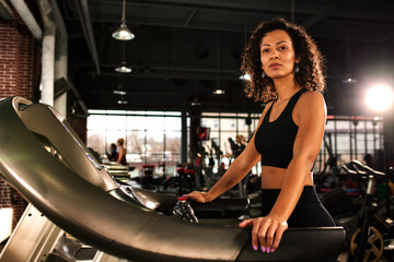 Fototapeta premium African American woman running on a treadmill in the gym.