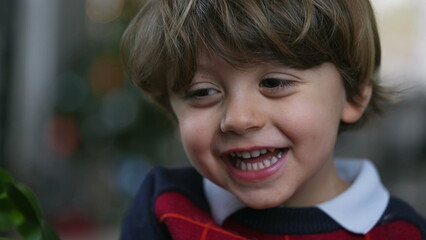 One adorable happy child laughing and smiling. Closeup face of joyful little boy authentic real life laugh and smile