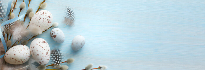 Easter composition with Easter eggs and spring flowers on blue table background