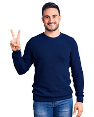 Naklejka premium Young handsome man wearing casual clothes showing and pointing up with fingers number two while smiling confident and happy.