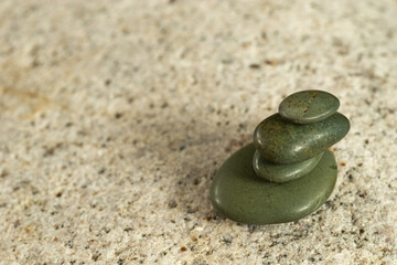 Fototapeta na wymiar Smooth Stacked Little Jade Pebbles On Granite
