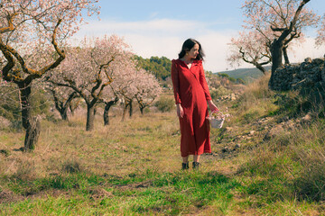 Woman walking in a spring environment with a white basket in her hand