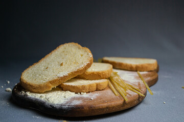 Bread, spaghetti and flour on gray background and wooden board