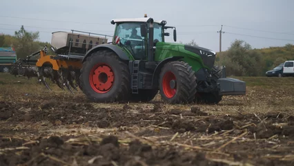 Tuinposter Tractor working in the field. Autumn tillage. Deep ripping with powerful tractor © Юрій Тарасовський