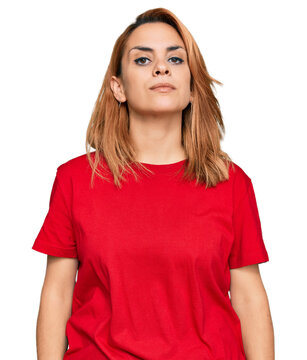 Hispanic Young Woman Wearing Casual Red T Shirt Relaxed With Serious Expression On Face. Simple And Natural Looking At The Camera.