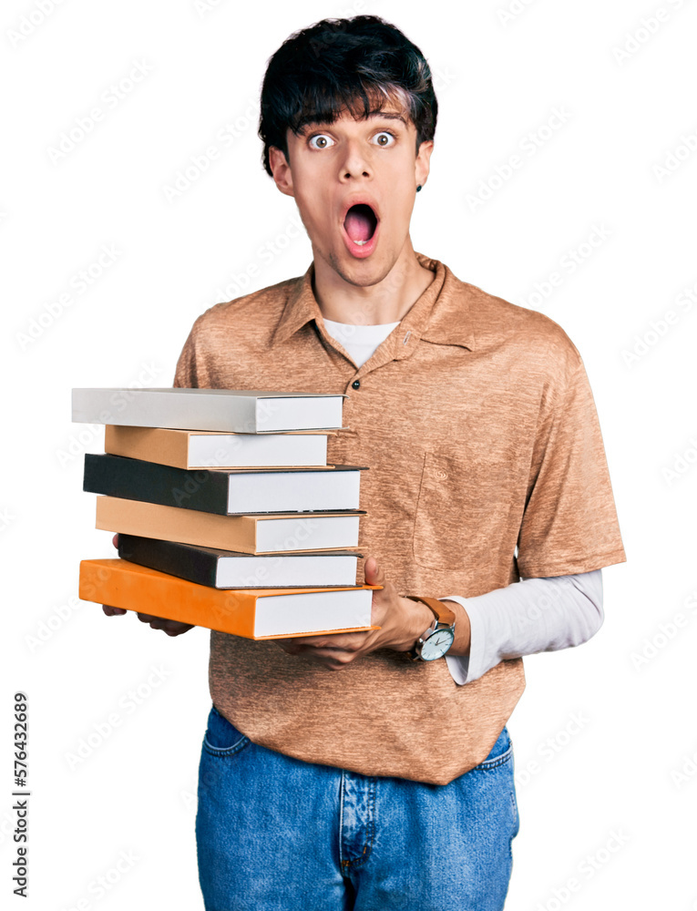 Canvas Prints handsome hipster young man holding a pile of books afraid and shocked with surprise and amazed expre