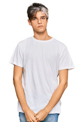 Fototapeta premium Young hispanic man wearing casual white tshirt with serious expression on face. simple and natural looking at the camera.