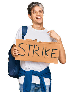 Young hispanic man holding strike banner cardboard pointing finger to one self smiling happy and proud