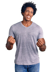 Handsome african american man with afro hair wearing casual clothes very happy and excited doing...