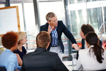 Obraz premium Distributing tasks to the team. Cropped shot of a group of business professionals in an office meeting.