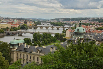 View on Prague city during summer with bridges over the Moldau river and houses, trees and churches, Czech republic.