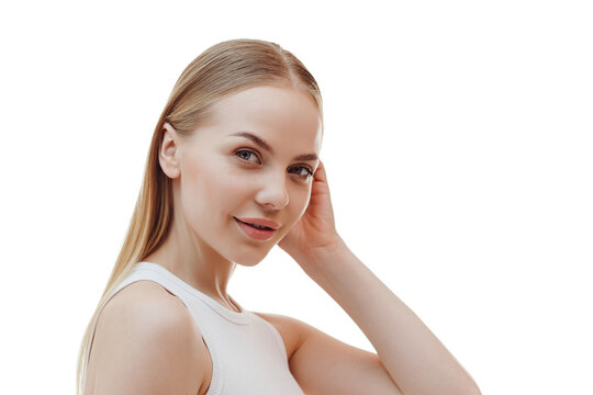 Beauty skin. Head and shoulders of blond woman model, touching glowing, hydrated facial skin, apply toner, skin cream or lotion for healthy look, after shower portrait, white background.