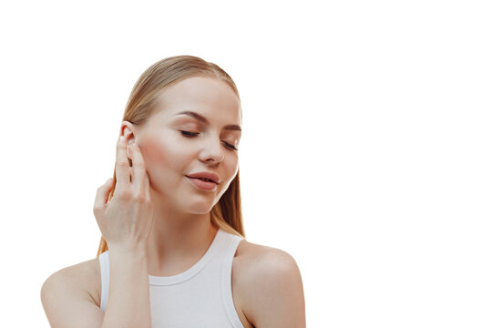 Skincare and spa. Smiling woman touches her clear, perfect facial skin after moisturizer, cosmetic cream, standing over white background