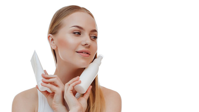 Beautiful blonde girl with a bottle of shampoos in hands. Girl with shiny and long hair. Woman long hair. Woman hold bottle shampoo and conditioner. Woman holding shampoo bottle.