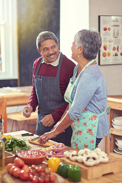 Its a healthy and happy retirement. Shot of a mature couple cooking together at home.