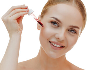 A beautiful young natural girl without makeup applies serum to her face with a pipette.Advertising...