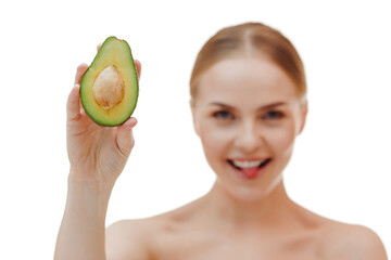 Pretty woman holds half an avocado in front of her face. Photo of attractive woman with perfect makeup on white background. Beauty & Skin care concept