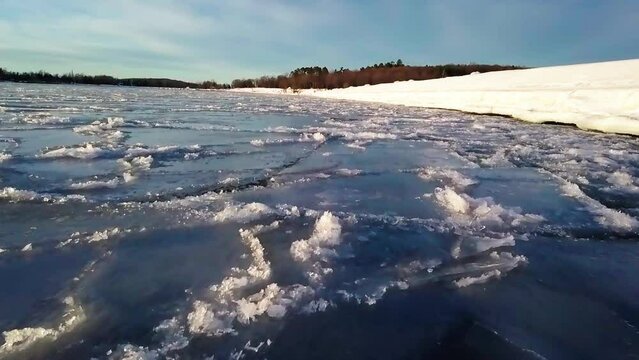 Tranquil View Of Ice Floating On Lake In Winter By Forest During Sunny Day - Marquette, Michigan