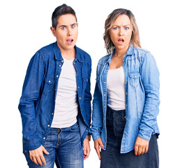 Couple of women wearing casual clothes in shock face, looking skeptical and sarcastic, surprised with open mouth