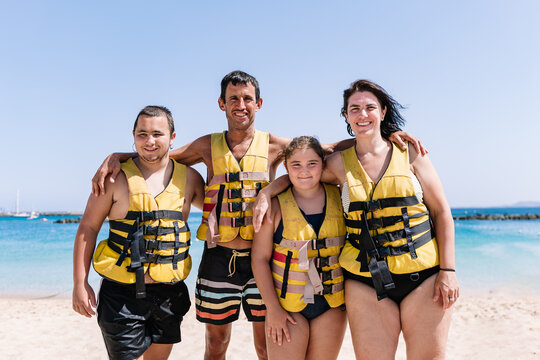 Group of cheerful family in swim safety jackets