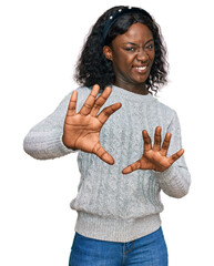 Beautiful african young woman wearing casual winter sweater disgusted expression, displeased and...