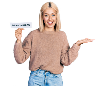 Beautiful young blonde woman holding ransomware banner celebrating achievement with happy smile and winner expression with raised hand