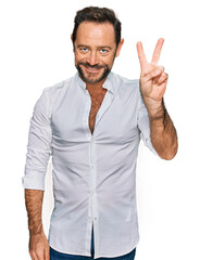 Middle age man wearing casual clothes showing and pointing up with fingers number two while smiling confident and happy.