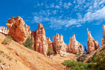 Fototapeta premium Close up scenic view of impressive Winy Pinnacles on Peekaboo hiking trail in Bryce Canyon National Park, Utah, USA. Massive steep hoodoo sandstone rock formations in natural amphitheatre in summer