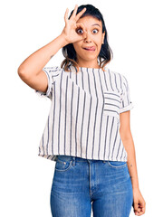Fototapeta premium Young woman wearing casual clothes doing ok gesture like binoculars sticking tongue out, eyes looking through fingers. crazy expression.