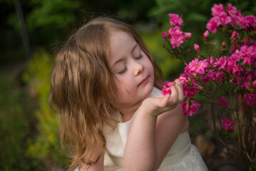 Obraz na płótnie Canvas portrait of a cute girl with a pink flower