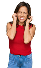 Young hispanic woman wearing casual clothes covering ears with fingers with annoyed expression for the noise of loud music. deaf concept.