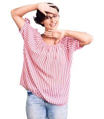 Fototapeta premium Beautiful young woman with short hair wearing casual summer clothes smiling cheerful playing peek a boo with hands showing face. surprised and exited