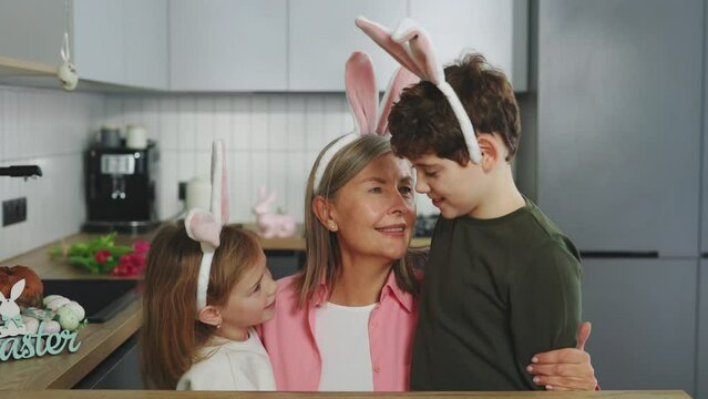 Happy Caucasian Family spending time together at home, joyfully talking. Kids and their Grandma preparing for Easter. Happy Easter