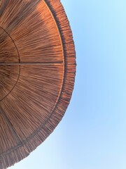 A cane beach umbrella and the beautiful sky.