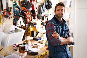 Lets fix it. Portrait of a handsome young handyman standing in front of his work tools.