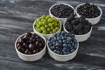 bowls with berries, a mix of fresh berries on a wooden table