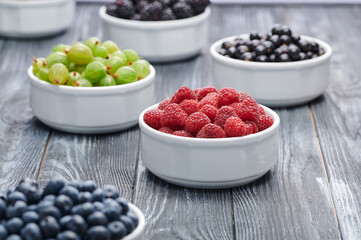 raspberries in a white bowl, blueberries, gooseberries, raspberries, blackcurrants, close-up shot