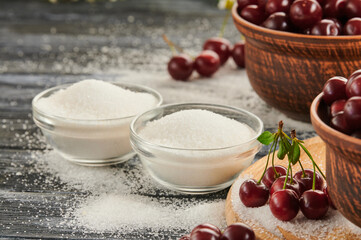 sugar for preservation in bowls on a wooden table, ripe cherries on the table