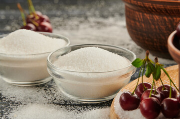 sugar for preservation in bowls on a wooden table, ripe cherries on the table