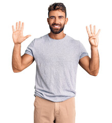 Naklejka premium Young hispanic man wearing casual clothes showing and pointing up with fingers number nine while smiling confident and happy.