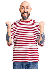 Naklejka premium Young handsome man wearing casual clothes celebrating surprised and amazed for success with arms raised and open eyes. winner concept.