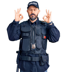 Young handsome man wearing police uniform relaxed and smiling with eyes closed doing meditation gesture with fingers. yoga concept.