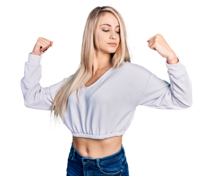 Beautiful young blonde woman wearing casual white sweater showing arms muscles smiling proud. fitness concept.