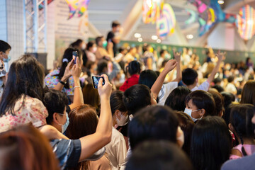 Crowd, group of young people kid, cheering in live music concert in front of colorful stage lights in school. Children event